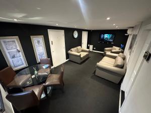 a living room with a table and chairs and a television at The Stables Room 1 in Takeley