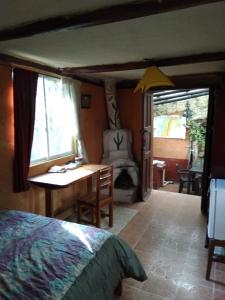 a bedroom with a bed and a desk and a chair at Quinta El Quinde in Otavalo