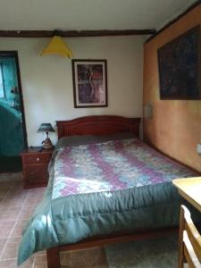 um quarto com uma cama grande e uma cabeceira em madeira em Quinta El Quinde em Otavalo