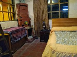 奧塔瓦洛的住宿－Quinta El Quinde，一间卧室配有一张床、一张桌子和一个窗户。