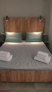 1 cama con 2 almohadas y 2 toallas. en Punto central Home in Heraklio city, en Heraclión
