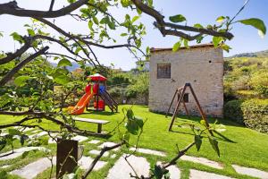 a garden with a playground and a building at Melograno Agriturismo La Ferla in Toirano