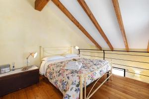 a bedroom with a bed in a room with wooden floors at Melograno Agriturismo La Ferla in Toirano
