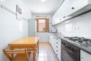 uma cozinha com uma mesa de madeira e um fogão em Antiga escola de Molinell em Culla