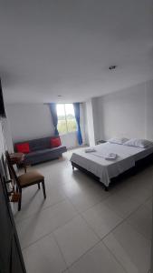 1 dormitorio con 1 cama grande y 1 silla en EDIFICIO MALU REAL habitaciones y apartaestudios sin cocina en Popayán