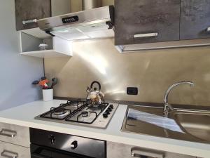 cocina con fogones y fregadero en Appartamento Pederzoli, en Peschiera del Garda