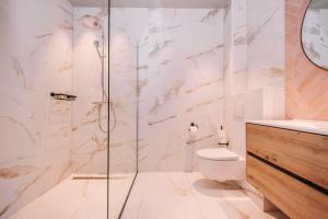 La salle de bains est pourvue de toilettes et d'une douche en verre. dans l'établissement Hotel Keur - Apartments, à Zandvoort