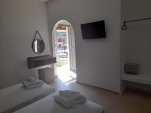 a white room with two beds and a tv on the wall at Euphoria ComplexB in Kavos