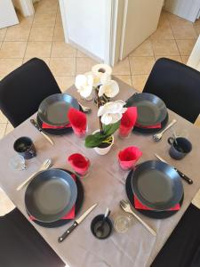 una mesa con platos, utensilios y flores. en Appartamento Pederzoli, en Peschiera del Garda
