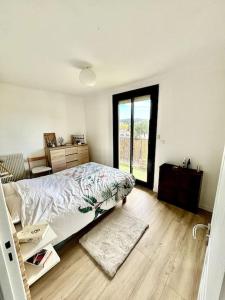 een witte slaapkamer met een bed en een raam bij Beau T3 moderne et lumineux in Aix-en-Provence