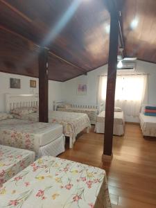 a bedroom with four beds in a room at Pousada Recanto da Fé in Cachoeira Paulista