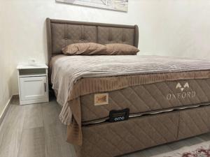 een bed in een slaapkamer met een bord erop bij Max Apartments in Podgorica