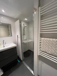 ein Bad mit einer Dusche und einem Waschbecken in der Unterkunft It Winkelhûs in Terschelling