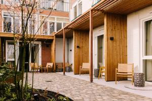 a courtyard of a building with chairs and tables at Hotel Keur - Apartments in Zandvoort