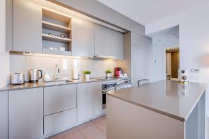 a kitchen with white cabinets and a large island at 1BR Condo - City View, Near CN Tower & Rogers Center in Toronto