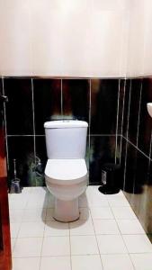 La salle de bains est pourvue de toilettes blanches et de carrelage noir. dans l'établissement ORAN Frange Maritime, à Oran
