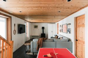 een woonkamer met een bank en een tafel bij Alpine Lake House - Waterfront on Lake Muskoka in Port Carling