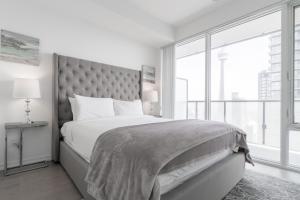una camera con un grande letto e una grande finestra di 1BR Condo - City View, Near CN Tower & Rogers Center a Toronto