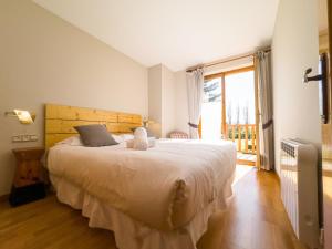 una camera con un grande letto e una grande finestra di Green Valley Puigcerdà a Puigcerdà