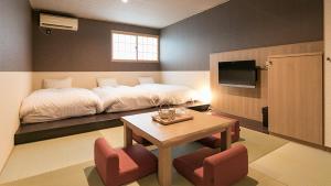 1 dormitorio con 1 cama, mesa y sillas en Asobe, en Aso