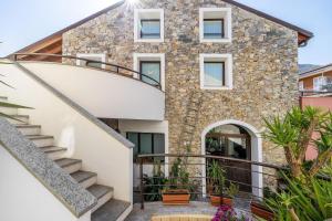 a stone house with a staircase in front of it at Ciliegio Agriturismo La Ferla in Toirano