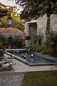 una mesa de billar en un jardín con pelotas. en La Maison Mulatô, demeure privée d'hôtes, piscine & spa Libourne, Saint-Emilion en Libourne