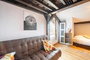 sala de estar con sofá y cama en Chez Malou Hugo, en Saint-Gingolph