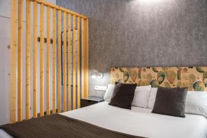 una camera da letto con un grande letto bianco con testiera gialla di Nou 10 a Barcellona