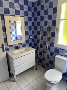 a blue tiled bathroom with a sink and a toilet at Dolce Vita in Propriano