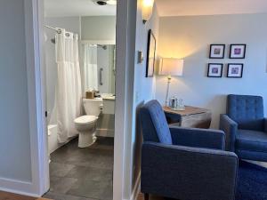 baño con sillas azules y baño con aseo en The Bradley Inn en New Harbor