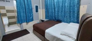 a bedroom with a bed and a bathroom with a toilet at Sobey Laris Roomstay GUA MUSANG in Gua Musang