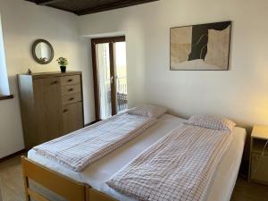 una camera con due letti, un comò e una finestra di Bella Fosano Casa a Gambarogno