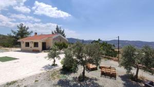 a house with a bench and trees in front of it at House on a Hill with Stunning Views near Troodos in Silikou