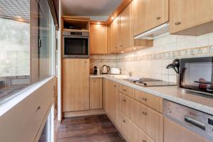 eine Küche mit Holzschränken und einer Arbeitsplatte in der Unterkunft Appartement Sun Valley in Chamonix-Mont-Blanc