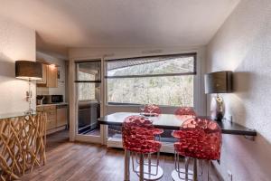 eine Küche mit einem Tisch und 2 roten Stühlen in der Unterkunft Appartement Sun Valley in Chamonix-Mont-Blanc