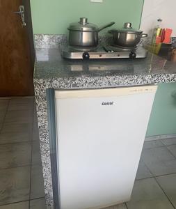 - un comptoir de cuisine avec 2 casseroles sur une cuisinière dans l'établissement Suite equipada com cozinha , conforto e paz !, à Brasilia