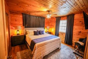 ein Schlafzimmer mit einem Bett in einem Blockhaus in der Unterkunft The Lodge at Mt. Hersey in Hasty