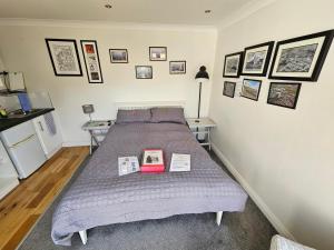 Un dormitorio con una cama con dos libros. en Modern immaculate studio with aircon & parking en Bristol