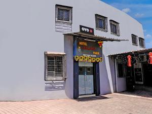 a white building with a sign above a door at Super OYO Kailash Park Near Shivaji International Airport in Mumbai