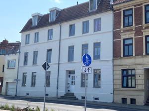 ein weißes Gebäude mit einem Straßenschild davor in der Unterkunft Work & Stay in Wismar in Wismar