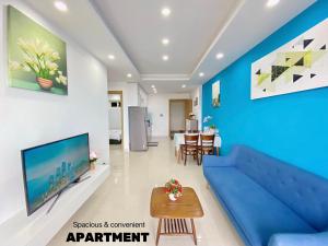 un salon avec un canapé bleu et une table dans l'établissement Căn hộ 2 phòng ngủ view biển Mỹ Khê Đà Nẵng, à Đà Nẵng