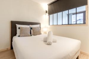 een slaapkamer met een groot wit bed en een raam bij Sun Valley II in Chamonix-Mont-Blanc