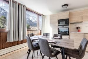 een eetkamer met een tafel en stoelen en bergen bij Sun Valley II in Chamonix-Mont-Blanc