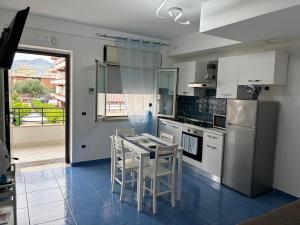 uma cozinha com uma mesa e cadeiras e um frigorífico em Acca residence em Terracina