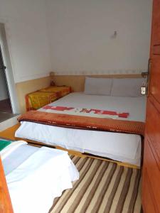 een slaapkamer met 2 bedden in een kleine kamer bij Hotel restaurant ait saderat in Boumalne