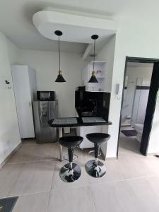 a kitchen with a table and two bar stools at 405 Moderno Aparta-Suite en Versalles Tipo Loft - Cali Tower Suites & Lofts in Cali