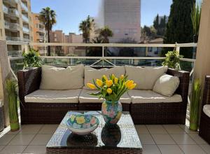 un sofá y un jarrón con flores en el balcón en Nice Riviera, en Niza