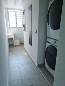 ein Bad mit einer Tür und Fliesenboden in der Unterkunft 405 Moderno Aparta-Suite en Versalles Tipo Loft - Cali Tower Suites & Lofts in Cali