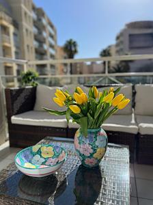 un jarrón lleno de flores amarillas sentadas en una mesa en Nice Riviera, en Niza