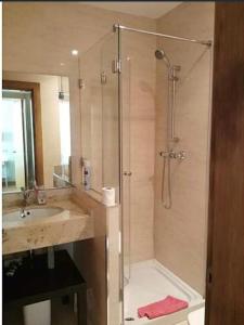 La salle de bains est pourvue d'une douche et d'un lavabo. dans l'établissement Primera Linea de Playa Comillas Cantabria, à Comillas